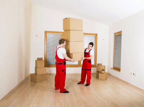 Professional movers protecting sofas and tables during transport